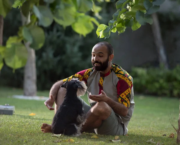 Homem e cão sentados na grama — Fotografia de Stock