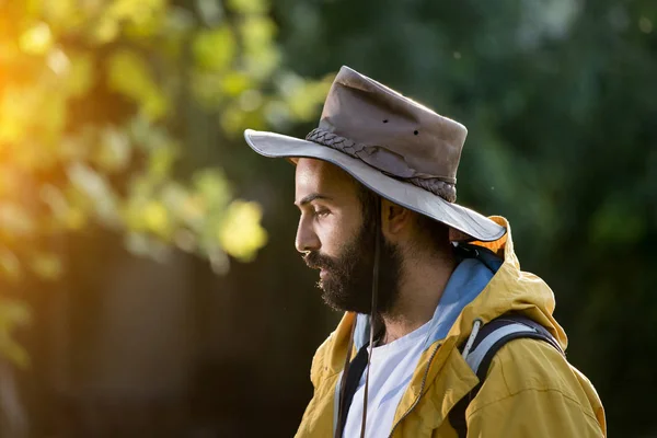 Hiker s pláštěnkou a kloboukem v přírodě — Stock fotografie