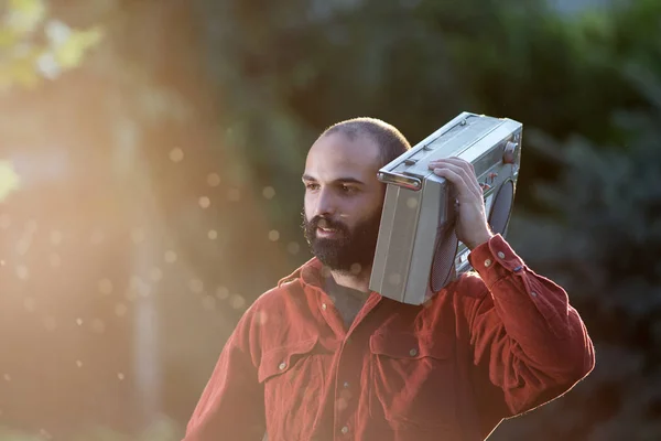 Mann hält Tonbandgerät auf Schulter im Park — Stockfoto
