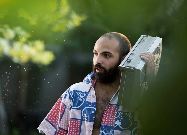 Человек держит магнитофон на плече в парке — стоковое фото