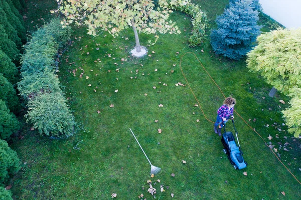 Повітряне зображення дівчини, що косить газон — стокове фото