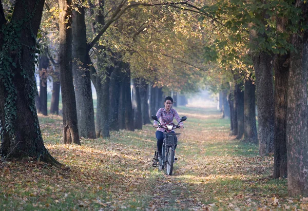 Mulher andando de bicicleta elétrica na floresta — Fotografia de Stock