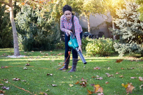 Frau benutzt Laubbläser im Garten — Stockfoto