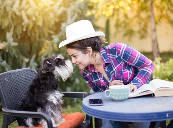 Девушка и собака сидят в саду — стоковое фото