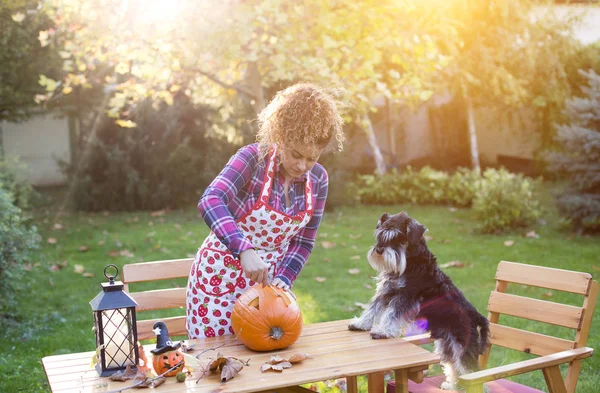 Mädchen und Hund schneiden Kürbis für Halloween — Stockfoto