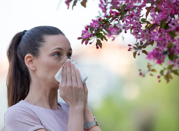 Wanita Cantik Muda Meniup Hidung Depan Pohon Mekar Konsep Alergi — Stok Foto