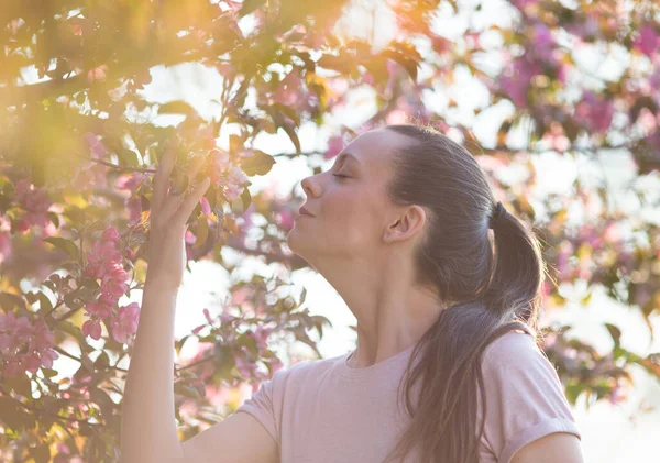 Όμορφη Νεαρή Γυναίκα Μυρίζει Όμορφο Ροζ Ανθισμένο Δέντρο Στον Κήπο — Φωτογραφία Αρχείου