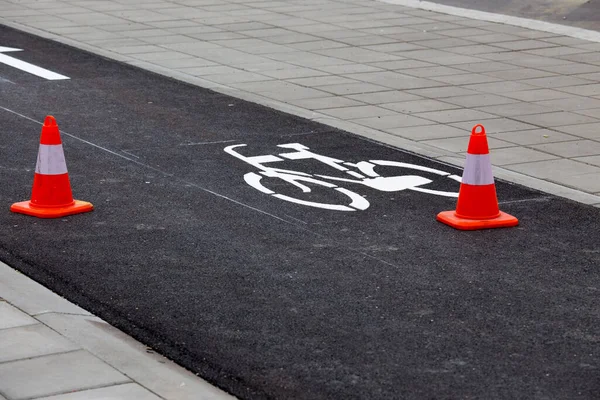 New bike lane with fresh paint of symbols and safety barriers on fresh asphalt