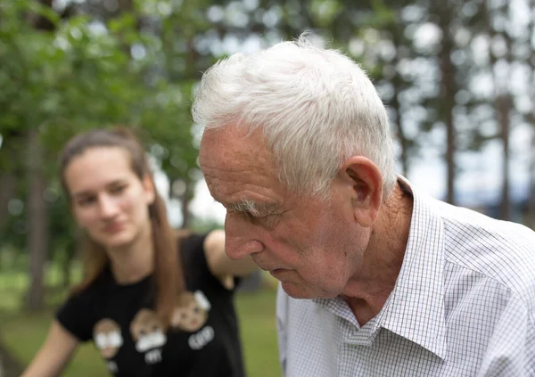 Teenagermädchen Tröstet Großvater Park Und Kümmert Sich Ihn — Stockfoto