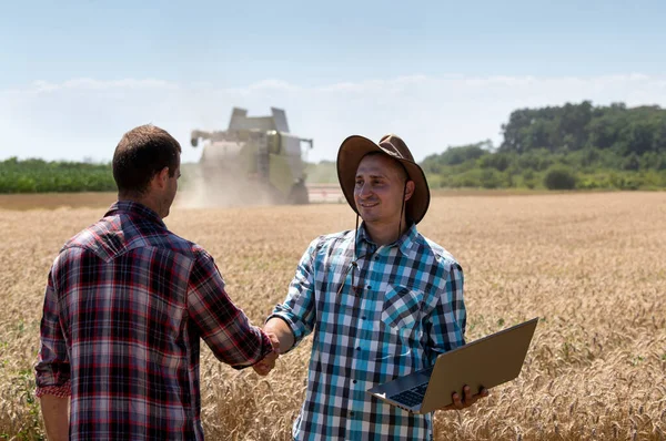 Dva Farmáři Při Sklizni Potřásají Rukama Pšeničném Poli Kombajnem Pozadí — Stock fotografie