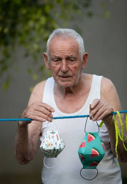 Homem Sênior Lavar Secar Máscaras Pano Segurança Cabide Jardim Durante — Fotografia de Stock