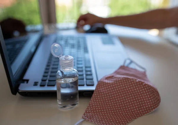 Sluiten Van Beschermende Stof Masker Desinfecterende Fles Voorkant Van Laptop — Stockfoto