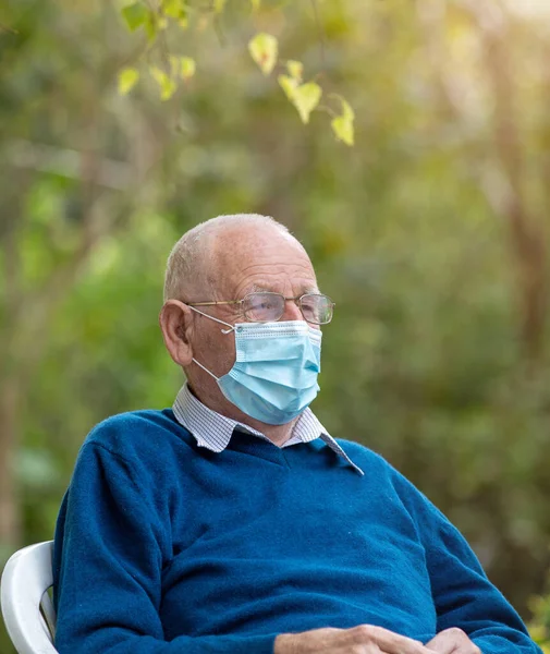 Senior Man Wearing Protective Mask Sitting Park Green Background Virus — Stock Photo, Image