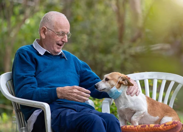 Senior Man Sitting Garden Laughing Dog Who Wearing Protective Mask — Stock Photo, Image