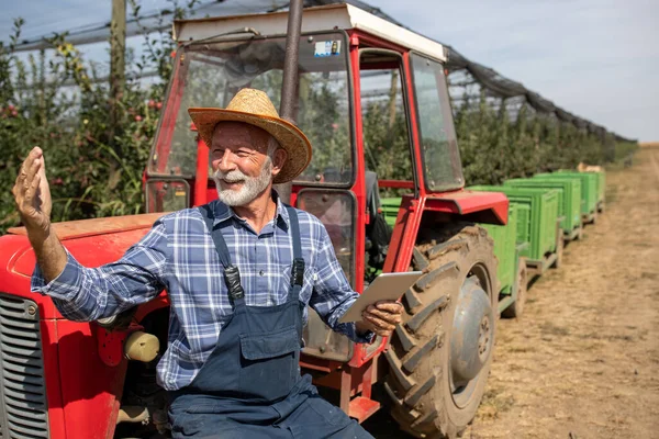 Tevreden Senior Boer Met Tablet Naast Trekker Met Plastic Kratten — Stockfoto