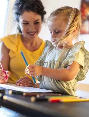 Anne ve genç kızı, gece boyunca doğal ışık ve konforlu ortamlarla çevrili, yaratıcı çizim seanslarına katılıyorlar.