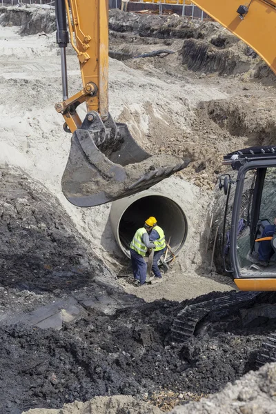 新型管道施工用挖掘机斗和工人做沟槽床 — 图库照片