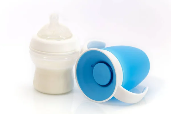 Baby infant no spill drinking cup and Baby bottle with milk — Stock Photo, Image