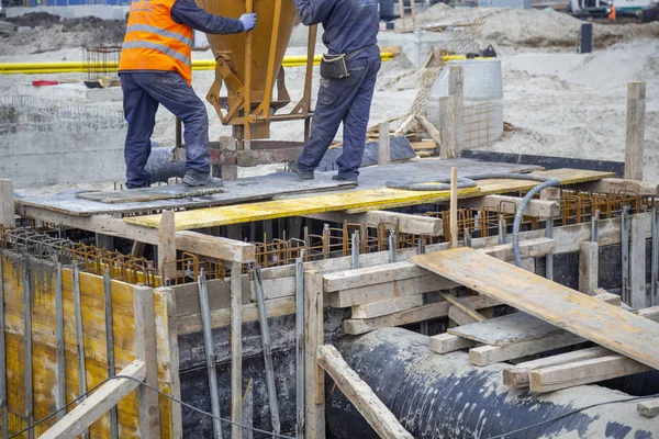 Trabalhadores da construção derramando com funil de concreto pular — Fotografia de Stock