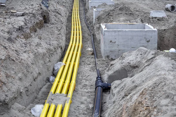 Żółty rurociąg PVC do systemów kablowych zakopanych w piasku — Zdjęcie stockowe