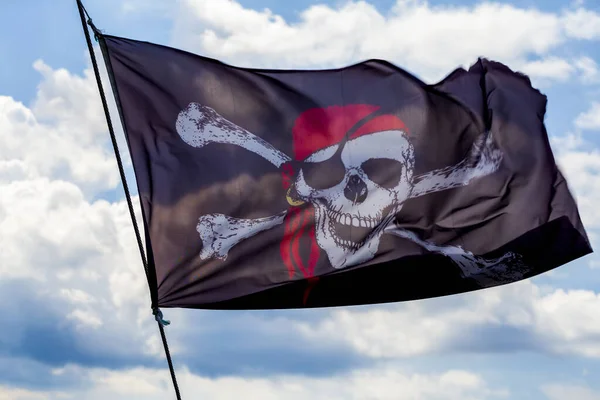 Pirate flag waving on the wind with a blue sky
