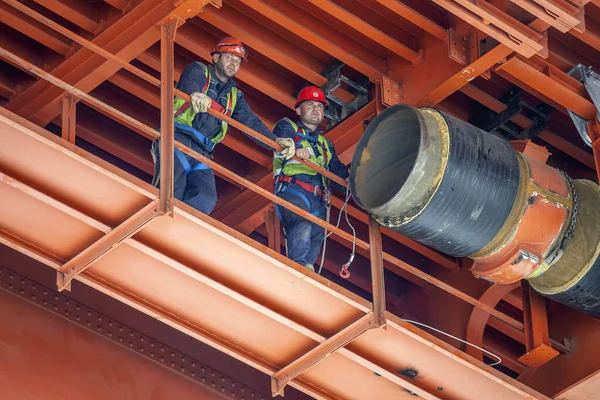 Trabajadores del metal posando durante la instalación de la tubería de calefacción urbana — Foto de Stock