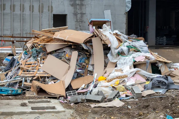 Σωρός Οικοδομικών Αποβλήτων Μπροστά Από Ημιτελές Κτίριο — Φωτογραφία Αρχείου