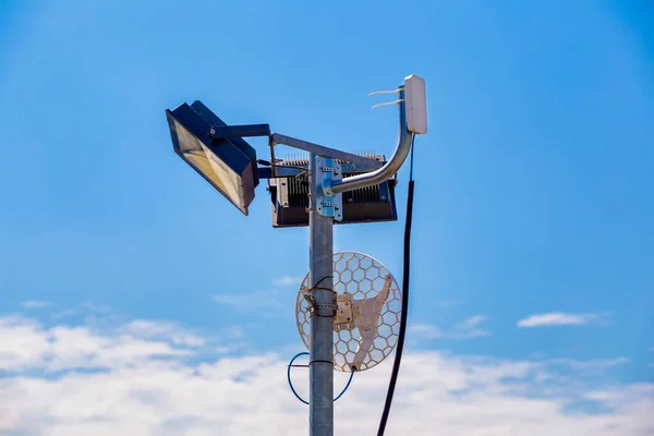 青空を背景に屋外の金属製のライトポール上の無線Lanアンテナ — ストック写真