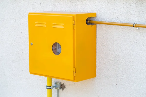 Domestic gas meter on wall outside mounted cabinet with yellow gas pipes. — Stock Image Domestic Gas Meter Wall Mounted Cabinet Yellow Gas Pipes Stock Photo