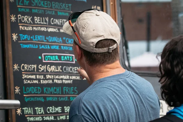 Man looks at menu at food truck event in Sanford, Florida.