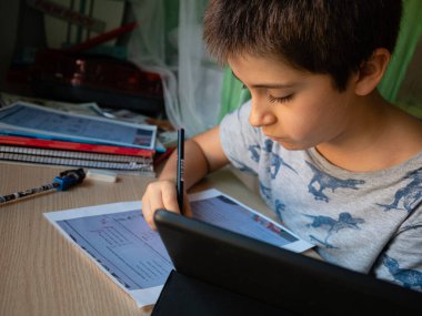 ÇOCUK ÇOCUKLARI, bir masa ve ev ödevini yapıyor