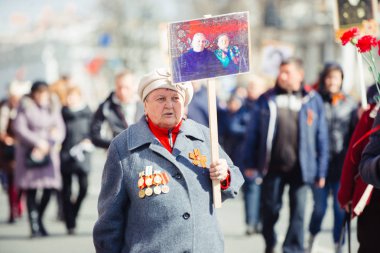 9 Mayıs 2017, Nevsky prospect, St. Petersburg, Rusya. 9 Mayıs'ta tatil, yaşlı bir kadın kalabalığın içinde Ölümsüz alayı eylem bir işareti taşır.
