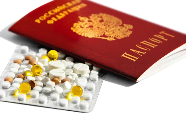 Sağlıklı bir yaşam tarzı kavramı, sağlıklı bir yaşam tarzı kavramı, hasta insanların tedavisi ve modern tıp. Beyaz ve renkli tabletler ve Beyaz arka planda Rus pasaportu yakın çekim.