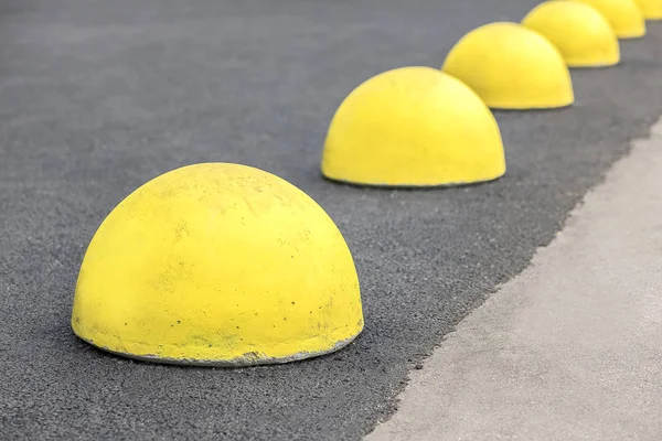 Arabanın park alanında sarı kısıtlayıcı hemisferler ve şehirde yol yüzeyinin onarım alanı.