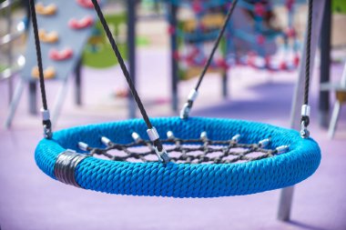 Oyun Alanı'nda mavi yuvarlak salıncak tipi yuva. Çocuklar ve ergenler için spor rekreasyon kavramı, mutlu bir çocukluk.