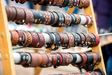 Farklı renklerde güzel deri bilezikustaların mevsimlik fuarında standında asılı.