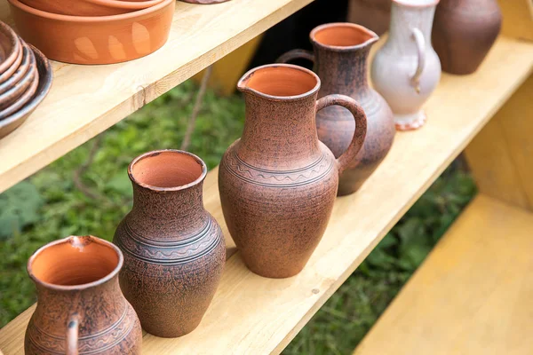 A lot of clay jars without frosting on the table at the fair of masters.