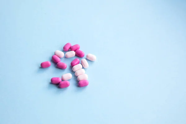 Belas pílulas rosa e branco no fundo azul . — Fotografia de Stock