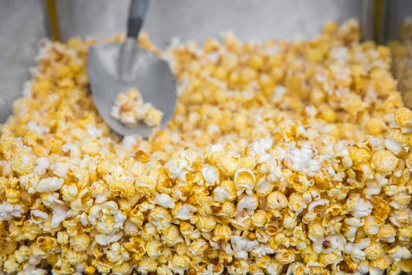 Machine with popcorn with a spoon inside close-up.