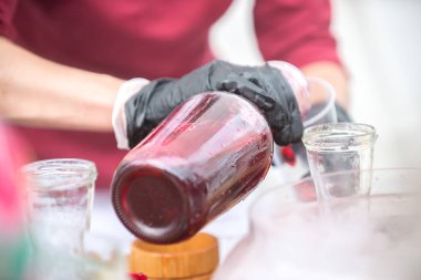 Bir kadın fuarda bir ev içki döker.