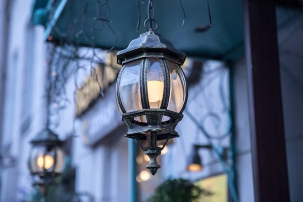 Beautiful wrought iron lanterns at the entrance to the house in the evening. — Stock Photo, Image