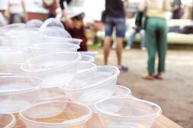 İnsanların arka planında boş plastik tabaklar. Çevre kirliliği kavramı.