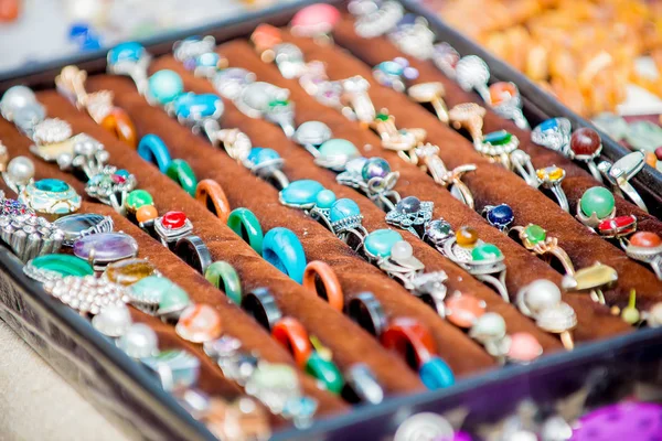 2019, Saint Petersburg, Rusya. Süs doğal taşlardan yapılmış yüzükler, turkuaz ve kadife siyah palet üzerinde gümüş metal diğerleri.