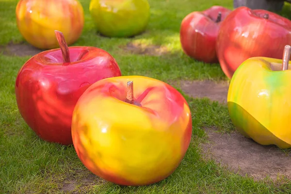 Un sacco di enormi mele rosse e gialle lucide decorative sull'erba verde . — Foto Stock
