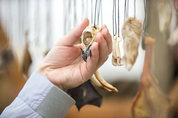 Bir adam bir kuşun kafasından sihirli bir tılsı tutar.