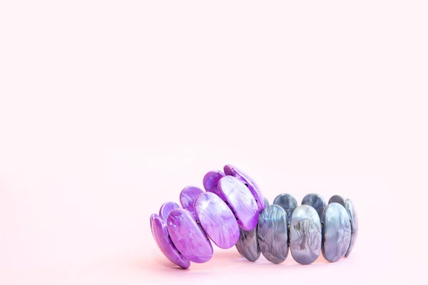 Pembe arka planda iki kadın plastik bilezik mor ve gri