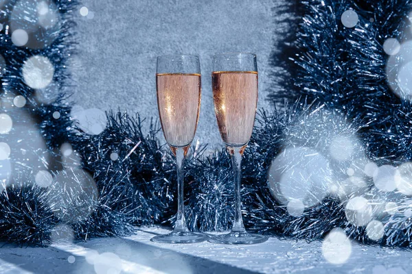 Zwei schöne Weihnachtsgläser mit Spritzern und Weihnachtsdekoration mit Bokeh im Vordergrund, geheimnisvoller Neujahrshintergrund. — Stockfoto