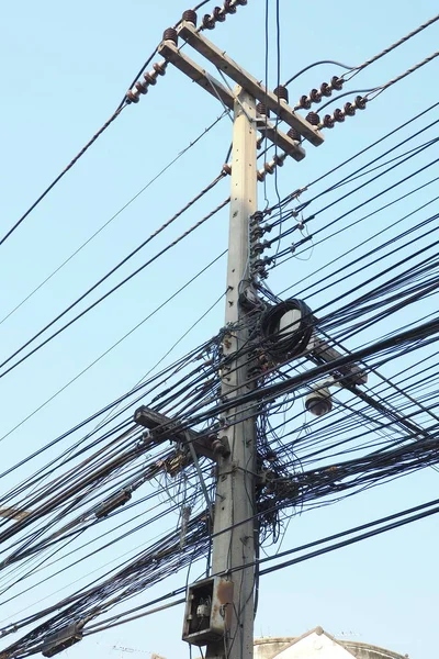 The power cord is tangled on an electric pole