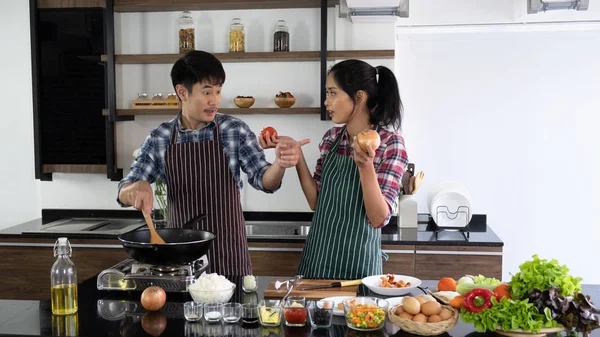 Young Asian couple are happy to cook together, two families are helping each other prepare to cook in the kitchen.