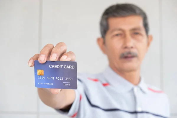 senior Asia man showing a credit card, business online concept,